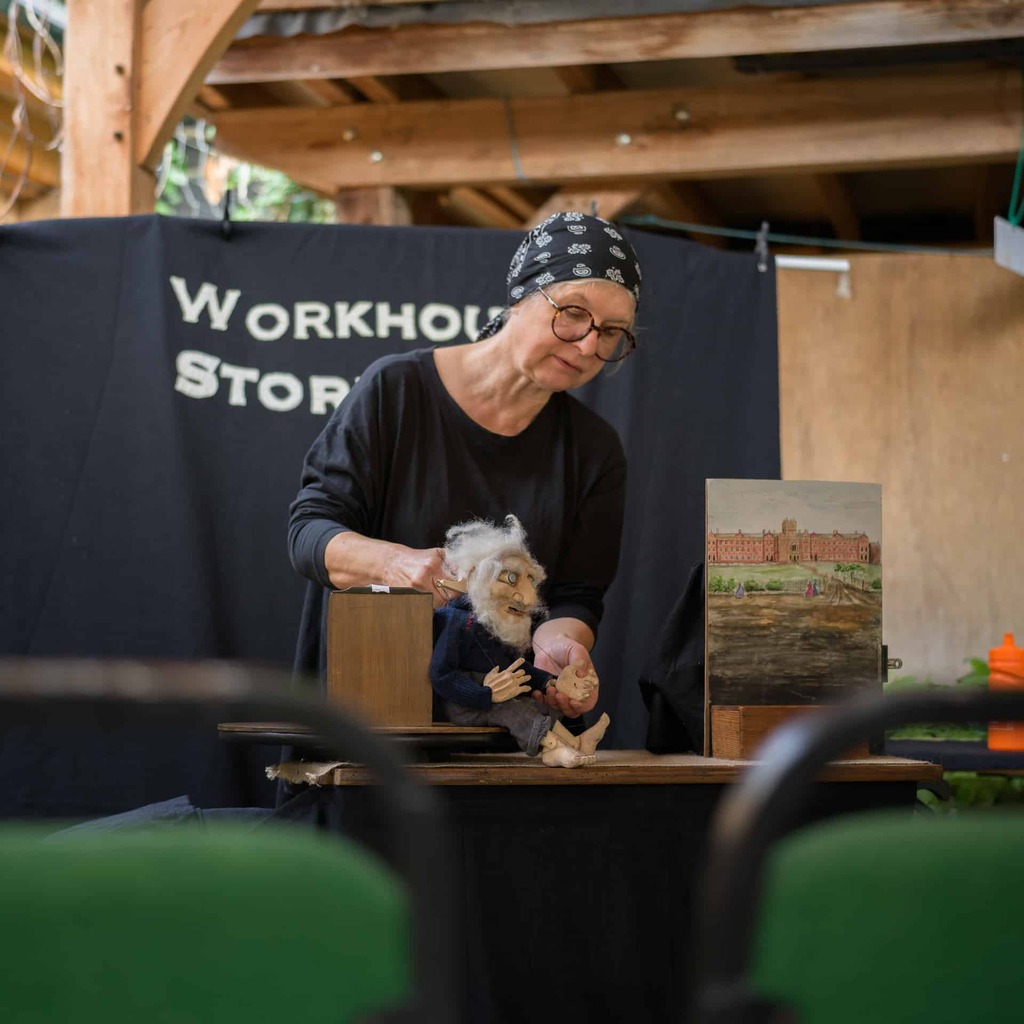 A photograph of a person performing puppetry.