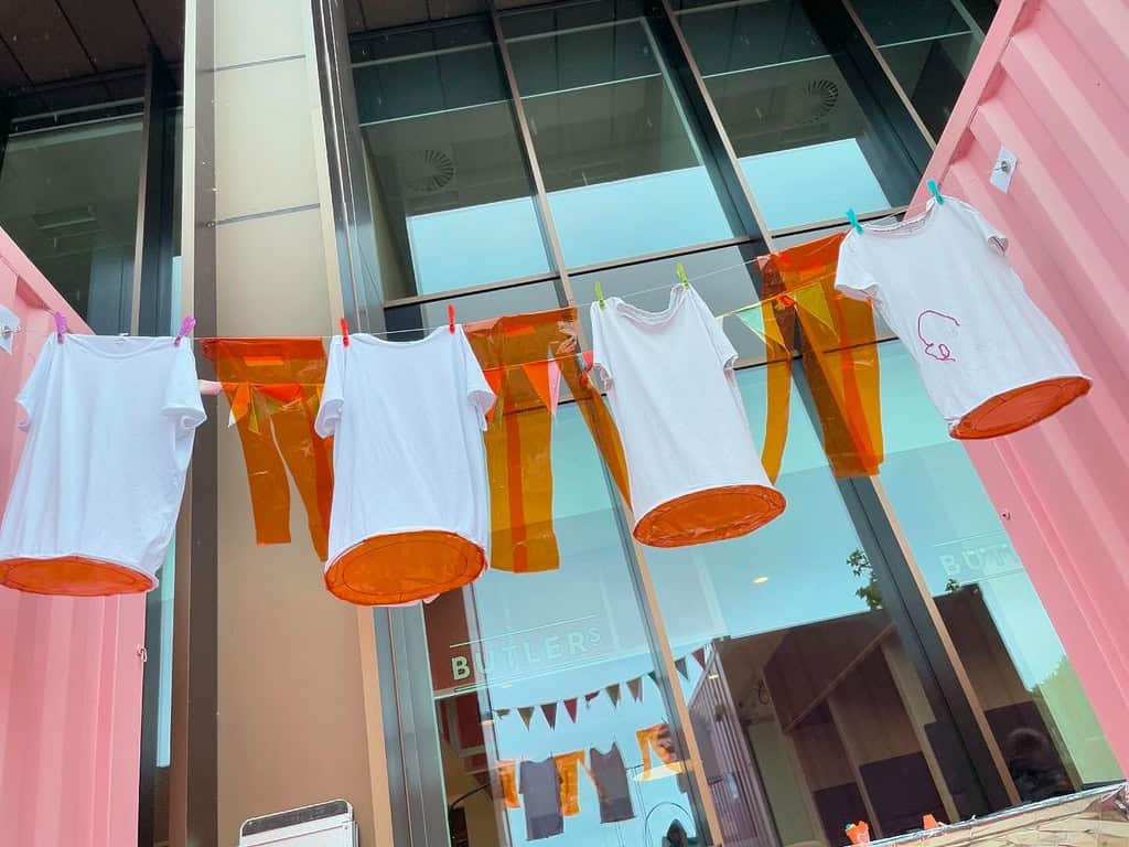 An art installation. With t-shirts hanging pegged from a washing line.