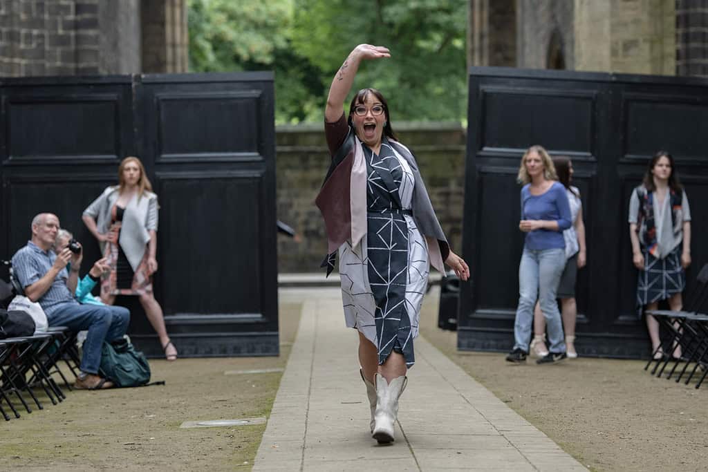 The model wears a wrap over dress with a jacket over the top.
