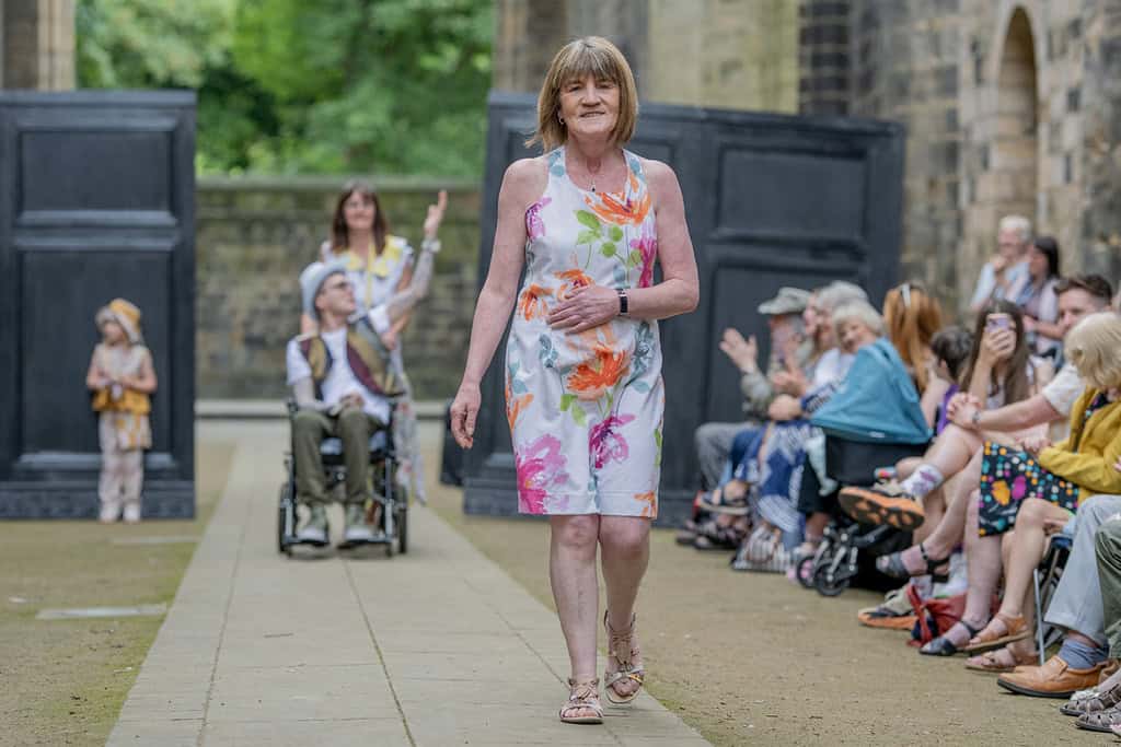 The model wears a flower patterned sleeveless dress.