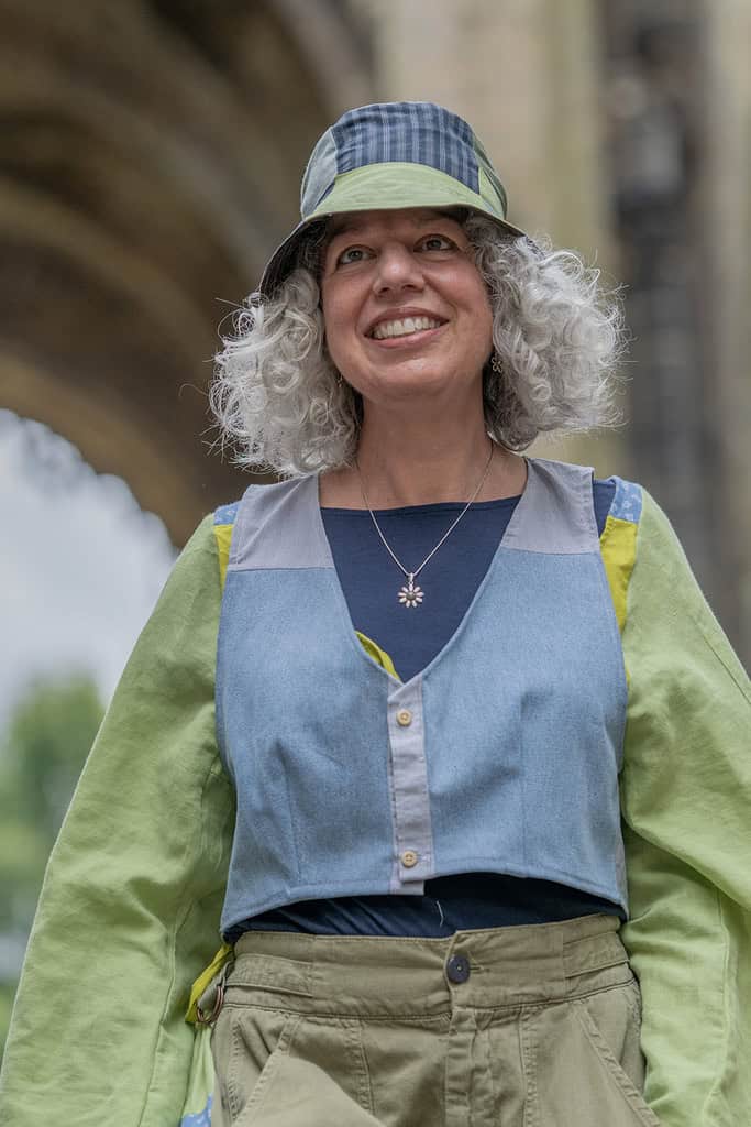 The model wears a long sleeve top and matching bucket hat