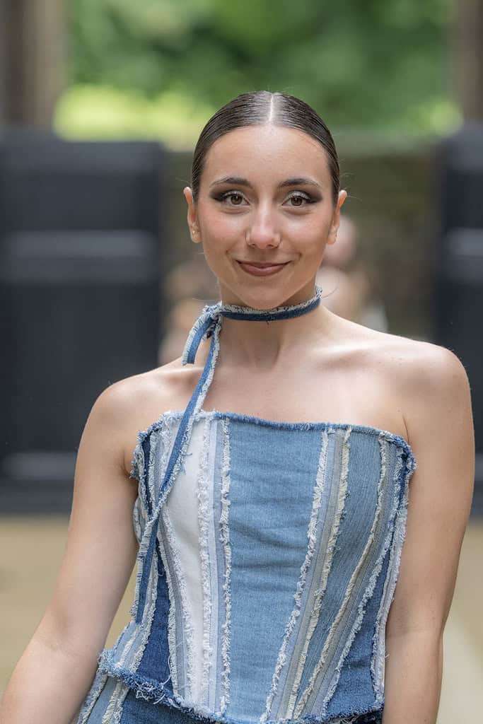 The model wears a sleeveless denim top