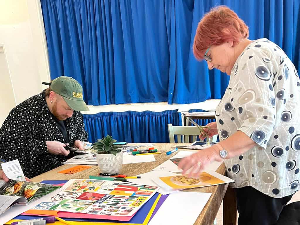 Two people creating art at a community workshop